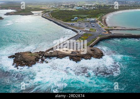 Vue aérienne d'une pointe rocheuse près d'un parking pilonné par de grandes vagues à Warrnambool sur la Great Ocean Road à Victoria, Australie Banque D'Images