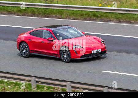 2023 Porsche Taycan 4X2 408PS Overboost 79.2Kwh Electric Auto Red car Saloon Electricité 240 kW se déplaçant à grande vitesse sur l'autoroute M6 dans le Grand Manchester, Royaume-Uni Banque D'Images