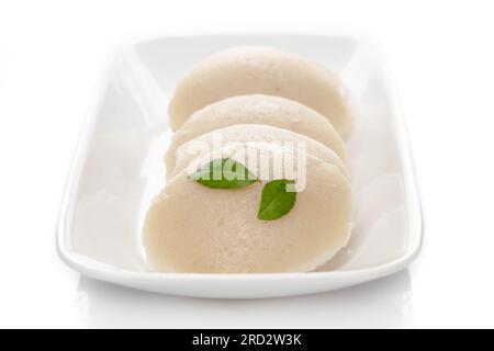 Gros plan de rava IDLI frais ou Idly with green curry leavest un plat populaire du sud de l'Inde, servi avec chutney de noix de coco. mise au point sélective Banque D'Images