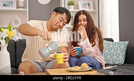 Homme et femme couple prenant le petit déjeuner versant du café sur la tasse à la maison Banque D'Images