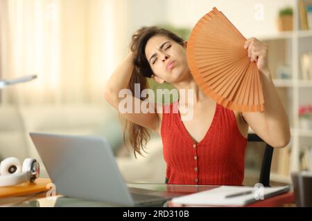 Etudiant stressé à la maison souffrant d'un coup de chaleur Banque D'Images