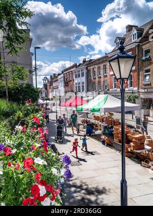 Guildford Market Day, High Street Shoppers et les enfants profitant d'un plaisir floral ensoleillé art et artisanat stands le jour du marché Guildford Surrey UK Banque D'Images