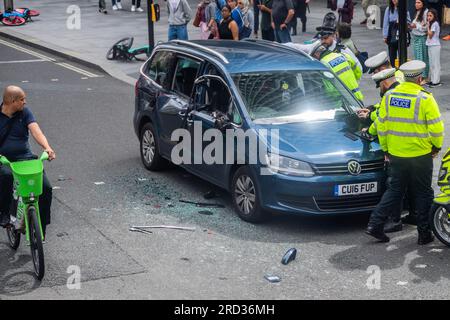 Londres, Royaume-Uni. 18 juillet 2023. La police de la circulation de moto assiste à un véhicule de location privé avec des dommages latéraux à la jonction de Tottenham court Road et Oxford Street. Crédit : Guy Bell/Alamy Live News Banque D'Images