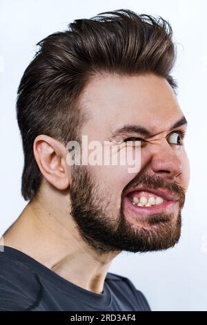 Jeune fou danger homme portrait émotionnel sur fond blanc Banque D'Images