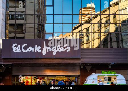 Panneau d'entrée dans le commerce de détail El Corte Ingles. Le paysage urbain se reflète sur le verre brillant dans le mur extérieur. Banque D'Images