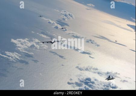 Les KC-135 Stratotankers du 203e escadron de ravitaillement en vol et les F-22 Raptors du 199e escadron de chasse volent en formation le 27 juin 2023 près de la côte d'Hawaï. Dans le cadre de l’opération Centennial Contact, l’événement national célébrait le 100e anniversaire du ravitaillement en vol. La 154e escadre a effectué un survol qui a eu lieu au-dessus des communautés à travers les parties sud et est d'Oahu. Banque D'Images