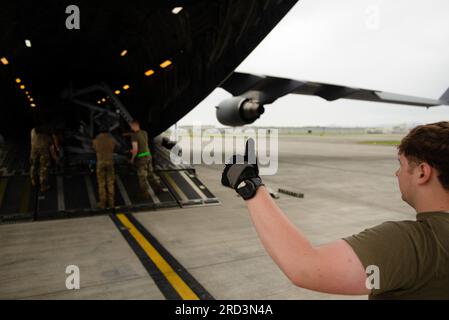 U.S. Air Force Senior Airman Tanner House, assigned to the 517th Airlift Squadron, guides Airmen from the 366th Fighter Wing as they off load equipment from a C-17 Globemaster III as part of Northern Edge 23-2 on Marine Corps Air Station Iwakuni, Japan, June 28, 2023. NE 23-2 is a first of its kind test of command and control capabilities throughout the region for a Joint, Multinational exercise event. Banque D'Images