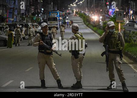 Des policiers de Manipur montent la garde lors d'un blocus routier imposé par le groupe de militantes des femmes Meira Paibi près du quartier Singjamei à Imphal pendant la manifestation. Les Meira Paibis sont des femmes Meitei qui viennent de toutes les couches de la société dans la vallée d'Imphal, sont largement respectées, elles ont une forte force morale. 'Meira' signifie 'lumière' et 'Paibi' signifie 'femme'. Ces femmes font partie d'un mouvement unique appelé 'Meira Paibi' qui émerge au Manipur. et ils ont protesté contre divers problèmes tels que les injustices sociales, les violations des droits de l'homme, la violence et la discrimination. Banque D'Images