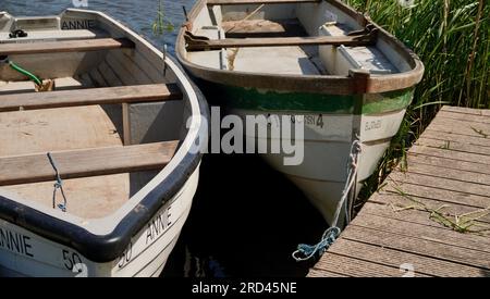 Des bateaux à rames vides en attente d'être loués pour des excursions autour du lac Llangorse dans cette attraction touristique des Brecon Beacons, au pays de Galles. Banque D'Images