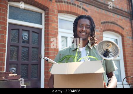 Portrait de jeune homme ou étudiant emménageant dans la maison appartement ou appartement tout en étudiant à l'université ou au collège Banque D'Images