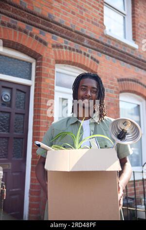 Portrait de jeune homme ou étudiant emménageant dans la maison appartement ou appartement tout en étudiant à l'université ou au collège Banque D'Images