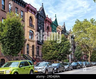 Bedford Stuyvesant : 1899 maisons de ville en grès brun sur Greene Street avec de hauts stops et des corniches métalliques élaborées, peintes. Banque D'Images