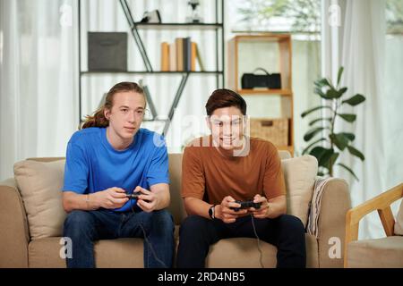 Meilleurs amis jouant à des jeux vidéo ensemble à la maison Banque D'Images