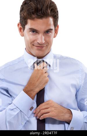 Habillé pour le succès. Un beau jeune homme d'affaires ajustant sa cravate. Banque D'Images