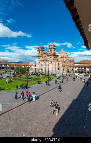 Les gens sur la Plaza de Armas place principale de Cusco avec l'église de la Société Jésuite de Jésus, Pérou. Banque D'Images