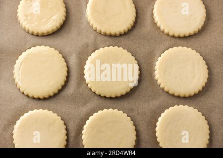 Sablés de lait avant la cuisson, graissés avec oeuf sur parchemin, vue de dessus. DIY, étape par étape, étape 9. Banque D'Images