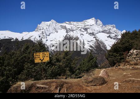 Panneau de direction et montagne enneigée. Scène près de Namche Bazar, Everest National Park Banque D'Images