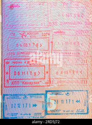 Timbres de passage des frontières avec les noms des postes frontière russes et kazakhs dans un passeport russe ouvert Banque D'Images