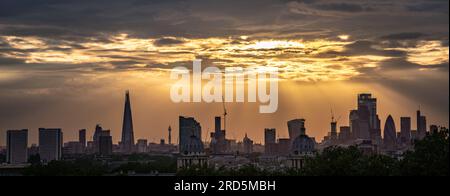 Londres, Royaume-Uni. 18 juillet 2023. UK Météo : des rayons de coucher de soleil spectaculaires vus au-dessus de la ville vu du haut de Greenwich Park termine une autre chaude journée d'été (multi-image, fusion de panorama). Crédit : Guy Corbishley/Alamy Live News Banque D'Images