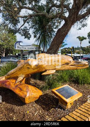 Paihia, Nouvelle-Zélande - 1 juillet 2023 : une sculpture figurative en bois représentant deux dauphins donne un Haere Mai (bienvenue en maori) aux visiteurs arrivant du fer Banque D'Images