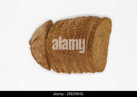 Pain noir tranché. Pain de seigle foncé avec cumin coupé en morceaux réguliers sur un fond blanc. Pain noir de blé sur la table. Isolé. Son de grain. Banque D'Images