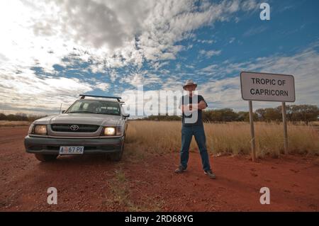 Homme et véhicule avec signe marquant le tropique du Capricorne en Australie occidentale Banque D'Images