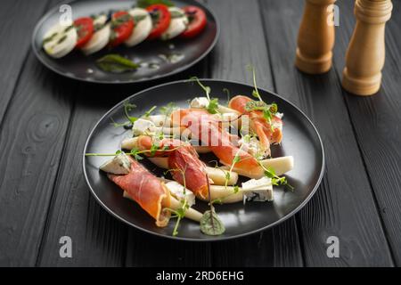 Apéritif avec poire, jambon prosciutto et fromage bleu sur un fond de bois foncé, alimentation saine pour perdre du poids. Banque D'Images