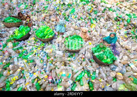 Dhaka, Bangladesh. 19 juillet 2023, Dhaka, Dhaka, Bangladesh : des ouvriers trient des bouteilles en plastique usagées dans une usine de recyclage à Dhaka, Bangladesh. Les employés aident à éviter que les bouteilles ne soient jetées, envoyées à la décharge, où elles peuvent prendre 1 000 ans à se biodégrader, ou incinérées, ce qui produit des fumées toxiques. La capitale bangladaise, Dhaka, étant l'une des plus densément peuplées au monde et abritant près de 19 millions d'habitants, la consommation annuelle de plastique par habitant de Dhaka est plus de trois fois supérieure à la moyenne nationale des zones urbaines et s'élève à 22,25 kg. Crédit : ZUMA Press, Inc./Alamy Live News Banque D'Images