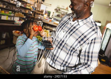 Grand-père et petit-fils afro-américains faisant des achats à l'épicerie biologique d'aliments naturels Banque D'Images