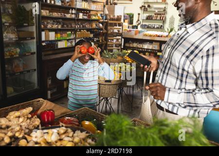 Grand-père et petit-fils afro-américains faisant des achats à l'épicerie biologique d'aliments naturels Banque D'Images