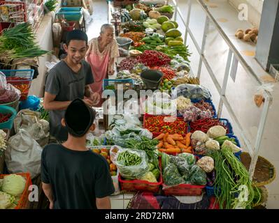 Yogyakarta-Indonésie, 9 juillet 2023 : un jeune homme vendant des acheteurs de légumes sur un marché traditionnel de Yogyakarta, en Indonésie Banque D'Images