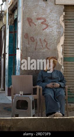 Homme assis devant un café en Egypte, Assouan Banque D'Images