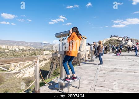 Femme regardant coin exploité jumelles télescopes touristiques trois beautés Cappadoce point touristique Turquie Banque D'Images