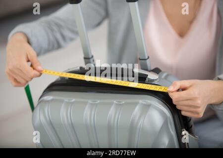 femme mesurant la valise avant le voyage Banque D'Images