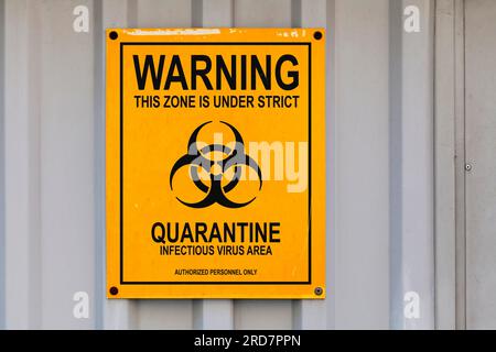 Panneau d'avertissement dessiné sur une plaque noire et jaune avec écrit en « Avertissement - cette zone est sous quarantaine stricte. Zone des virus infectieux. pe autorisé Banque D'Images