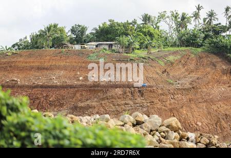 Chaîne de montagnes Malepunyo, Philippines. 19 juillet 2023 : Maison isolée au bord d'une carrière dans la montagne pour fournir sable, gravier et roches concassées pour le SLEX TR4. La route à péage South Luzon Expressway 4 fait partie du plus long projet autoroutier du pays, qui reliera Manille à Lucena dans un premier temps, puis à Matnog avec le projet SLEX TR5 signé en 2022, qui reliera les provinces de Quezon et Bicol par une route de 420 km. Depuis son élection, les groupes environnementaux ont exhorté le président Marcos à réduire la déforestation, les activités minières et les carrières. Crédit : Kevin Izorce/Alamy Live News Banque D'Images