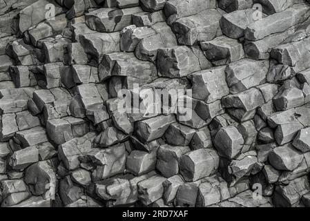 Texture de fond de colonne de basalte, montrant les roches noires de Reynisfjall, la montagne de la plage de Reynisfjara, Islande Banque D'Images