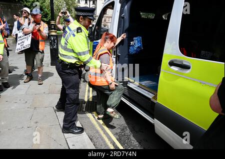 Londres, Royaume-Uni. Un militant de l'OSJ menotté et arrêté est aidé dans le transport de la police depuis la place. Just Stop Oil a marché aujourd'hui pour exiger que le gouvernement arrête tous les nouveaux projets pétroliers et gaziers. Crédit : michael melia/Alamy Live News Banque D'Images