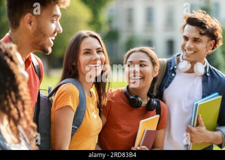 Belle étudiante marchant avec des amis du collège à l'extérieur Banque D'Images