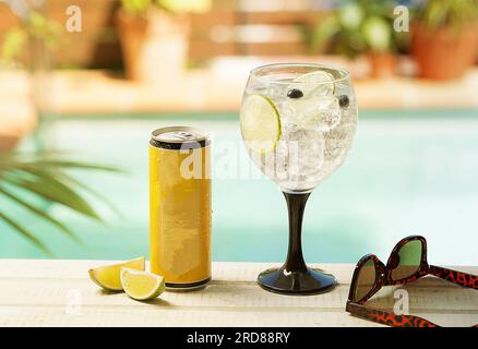 Invitation à une fête au bord de la piscine : boissons rafraîchissantes dans un verre au bord de la piscine Banque D'Images