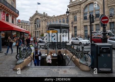 Paris, Île-de-France, France - 1 octobre 2022 : entrée de la station de métro sans signalisation avec des gens marchant de haut en bas des marches Banque D'Images