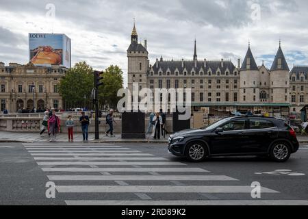 Paris, Île-de-France, France - 1 octobre 2022 : les touristes et les habitants attendent de traverser la rue par le Palais de la Cité avec la Tour de l'horloge où se trouve T. Banque D'Images