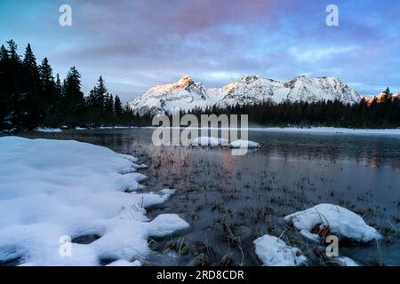 Montagnes enneigées entourant le lac gelé Entova, Valmalenco, Valtellina, Lombardie, Italie, Europe Banque D'Images