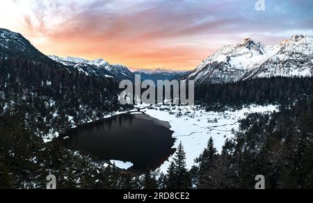 Vue panoramique aérienne de la forêt enneigée et du lac gelé Entova au lever du soleil, Valmalenco, Valtellina, Lombardie, Italie, Europe Banque D'Images