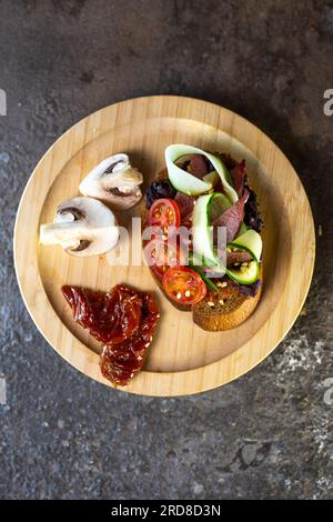 bruschetta avec légumes et viande tranchée. vue de dessus d'une collation dans un café. Banque D'Images