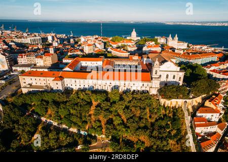 Vue aérienne par drone de Miradouro da Graca avec Panthéon national visible et grand bateau de croisière amarré sur le port du Tage, Lisbonne, Portugal Banque D'Images