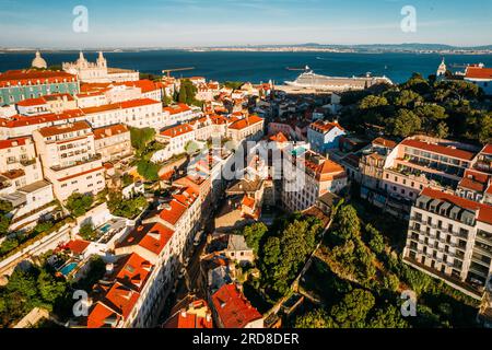 Vue aérienne de Miradouro da Graca avec Panthéon National visible à l'extrême gauche, et grand bateau de croisière amarré sur le port du Tage Banque D'Images