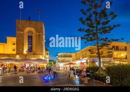 Vue de café et restaurant sur la place centrale Eleftherias dans la ville de Kos au crépuscule, Kos, Dodécanèse, Îles grecques, Grèce, Europe Banque D'Images