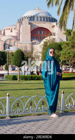 Femme en robe traditionnelle dans le parc Sultanahmet sur une soirée d'été avec la mosquée Sainte-Sophie derrière, Istanbul, Turquie Banque D'Images