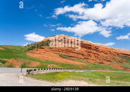 Image prise au virage dans le Road to Sunlight Basin au Wyoming. Chugwater est un grès rouge vu ici comme une grande crête de roche contre le ciel bleu. Banque D'Images